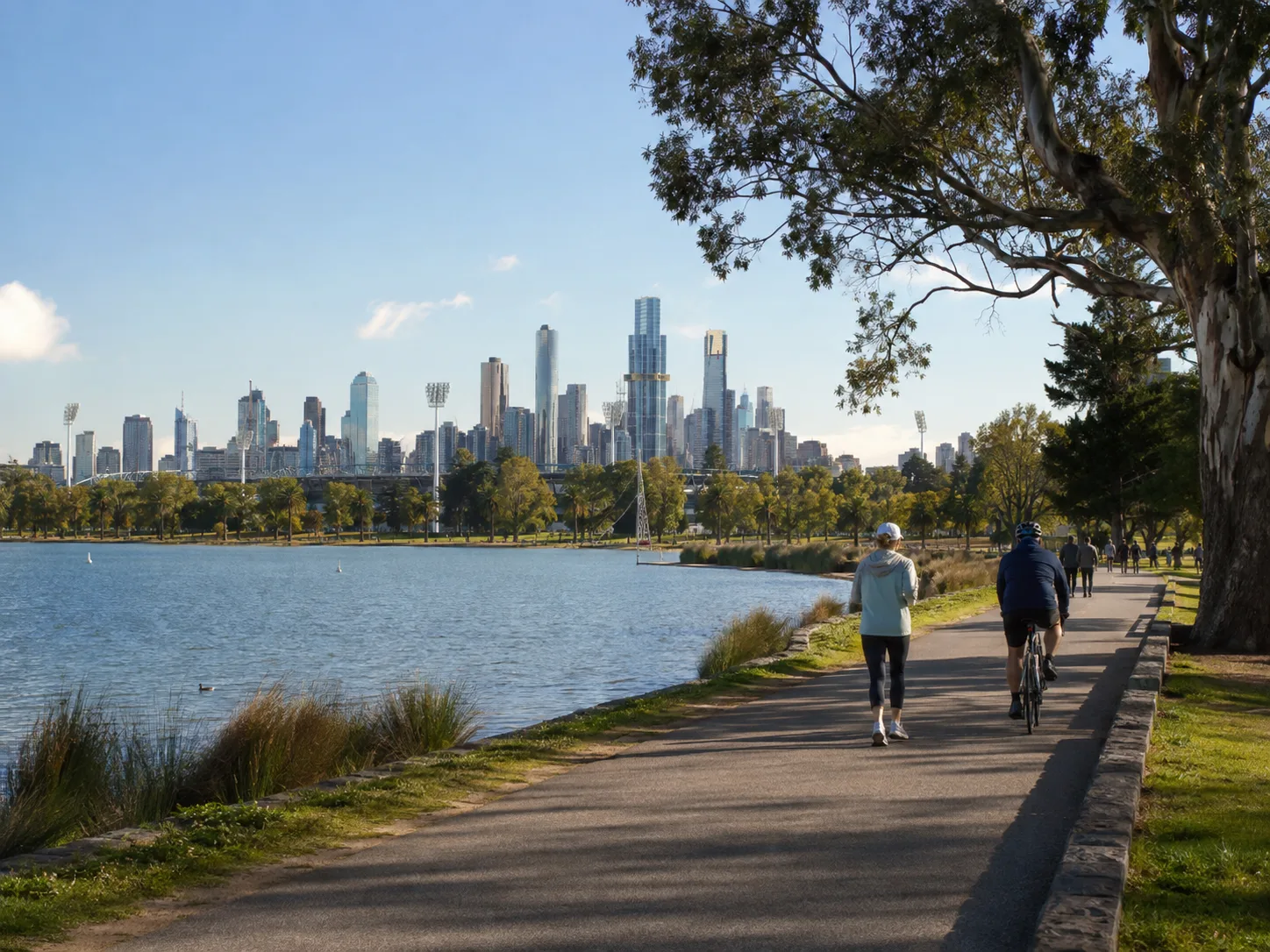 Walkers and a cyclist beside Albert Park Lake