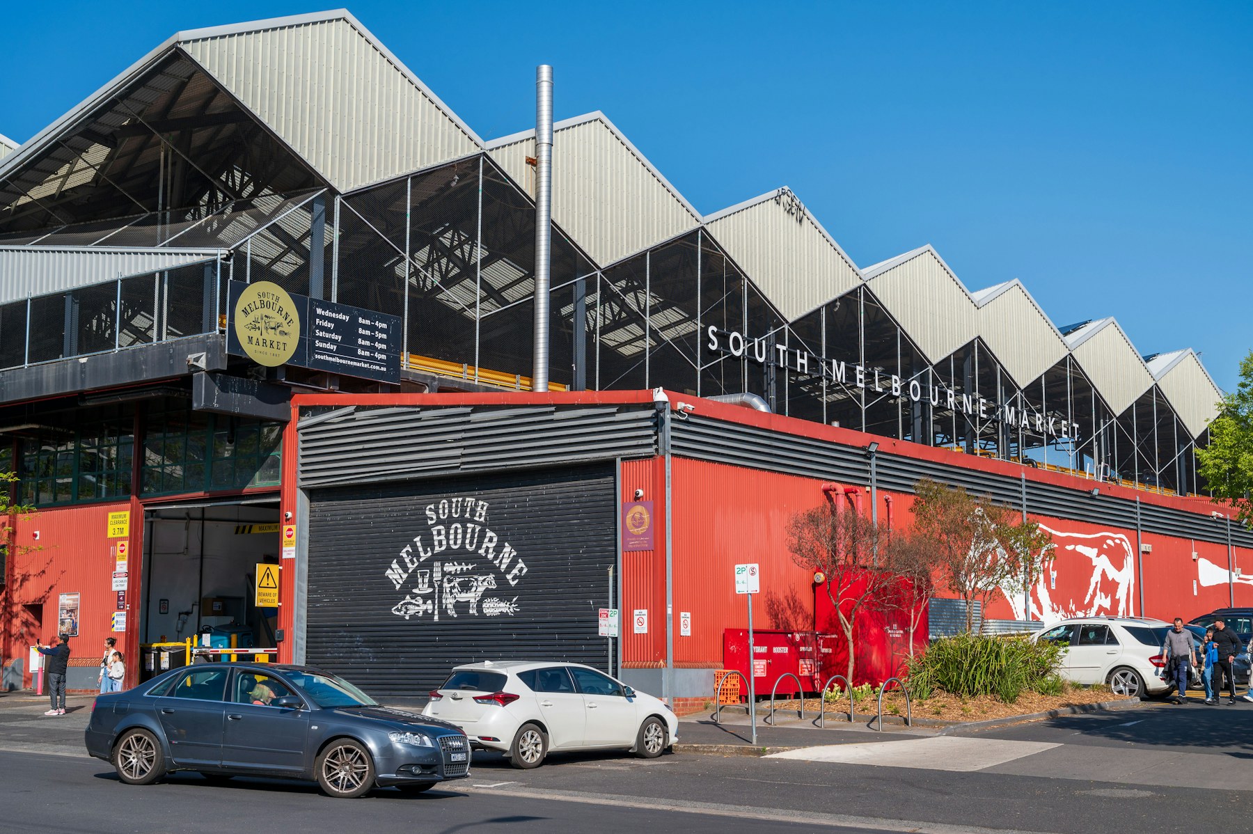 The red exterior of South Melbourne Market under a blue sky